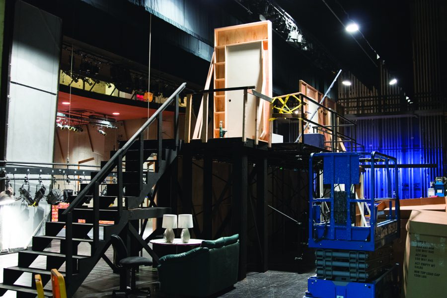 Picture of the state playhouse, backstage, with black stairs and one white door.