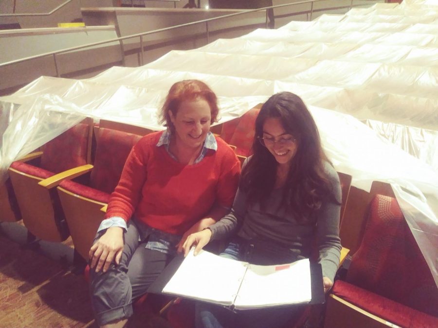 Old woman (left) and young lady (right) are discussing a journal and smile at the bright new future.