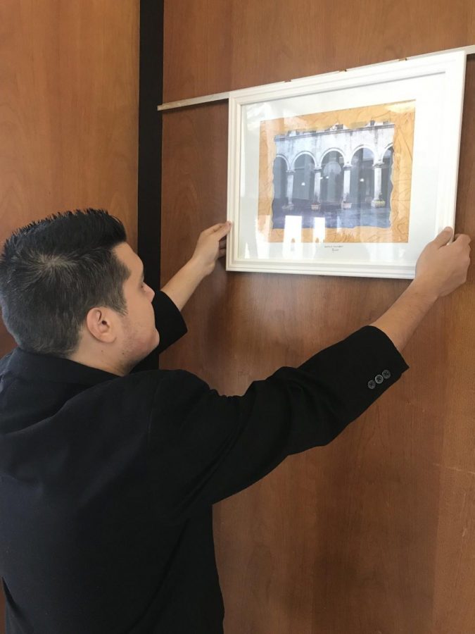 Basilio Alonzo hangs up his artwork at Alhambra city hall. (Daniel 
Lindley/Community News)