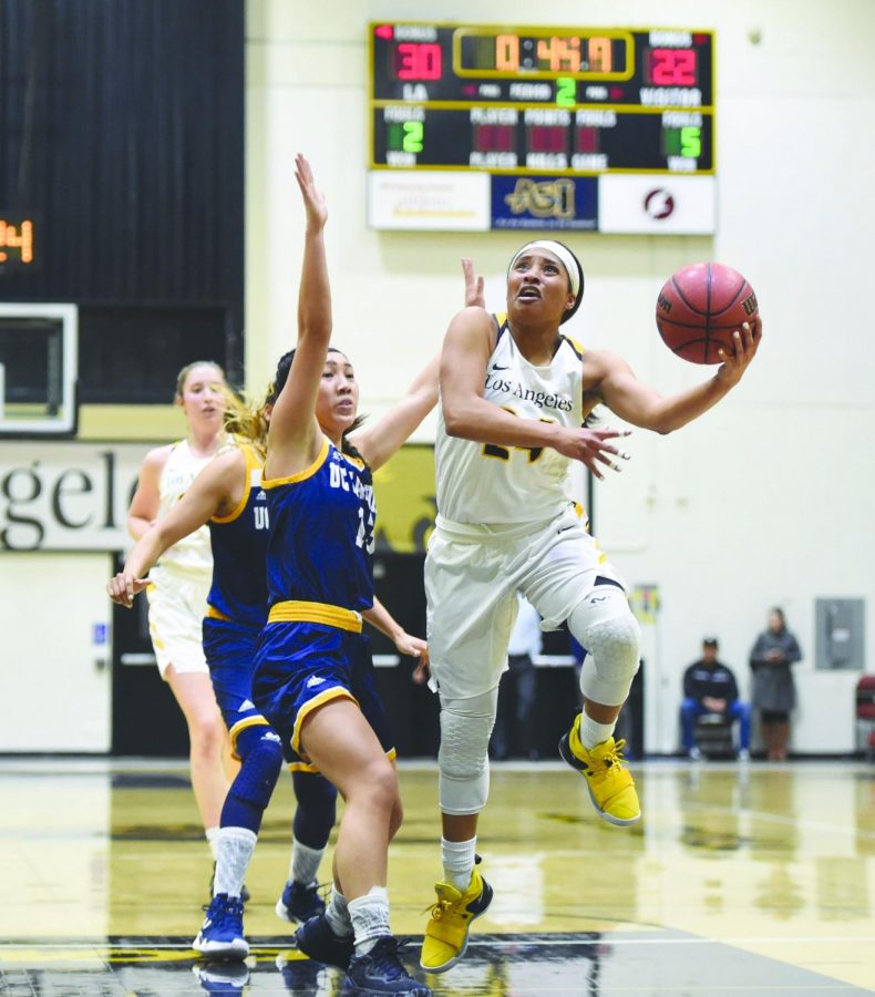 Heavily defended Golden Eagles Chiderah Uzowuru (24) drives to the hoop against UC San Diego Tritons Joleen Yang (13) Photo by Cal State LA Department/Robert Huskey