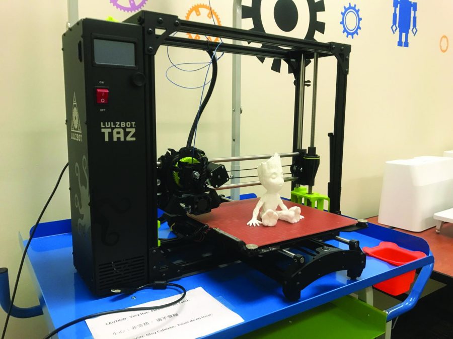 A Groot figurine sits on the 3D printer that created it.