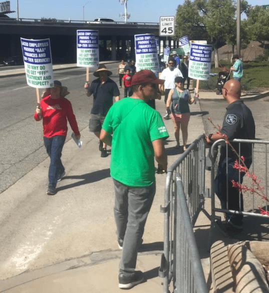 Sanitation workers protest in front of the street, in front of a security guard. (Courtesy of AFSCME District Council 36.)