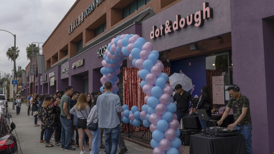 A line of people stretching down the sidewalk shortly before the grand opening of Dot _ Dough Doughnuts this past Saturday.