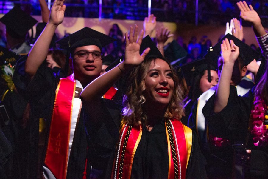 Graduates of Cal State Los Angeles's Arts and Letter Department wave to their family, friends, and supporters during the 2019 Cal State LA Commencement