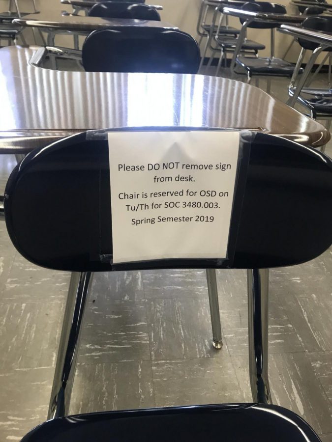 A sign indicates a seat that is accessible in a Cal State LA classroom.