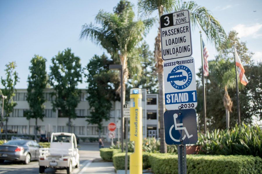 Signs indicating loading, access services, and handicap lay outside the Administration Building.