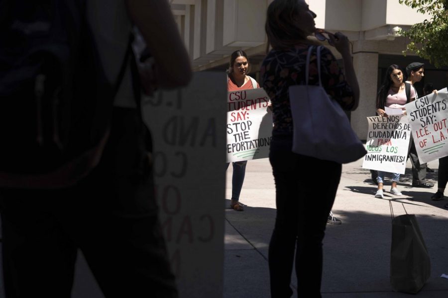 Students in support of the rally against I.C.E raids held signs with sayings protesting the immigration policies last Thursday next to the Golden Eagle statue at Cal State LA.