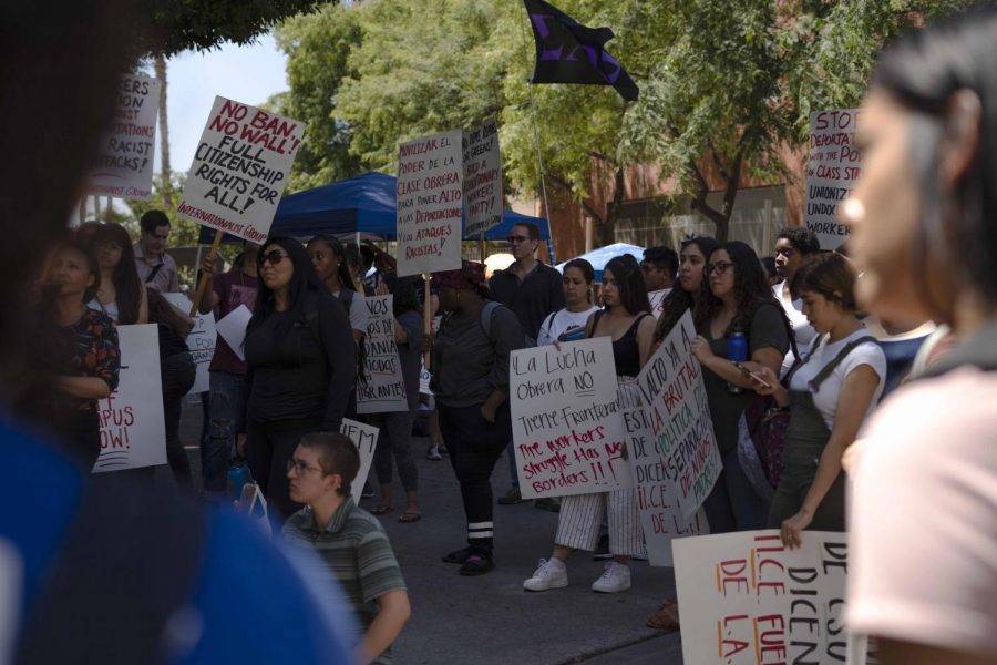 Signs protesting the border wall and other immigration policies were held by students during a rally against I.C.E raids that was held near the Golden Eagle statue last Thursday.