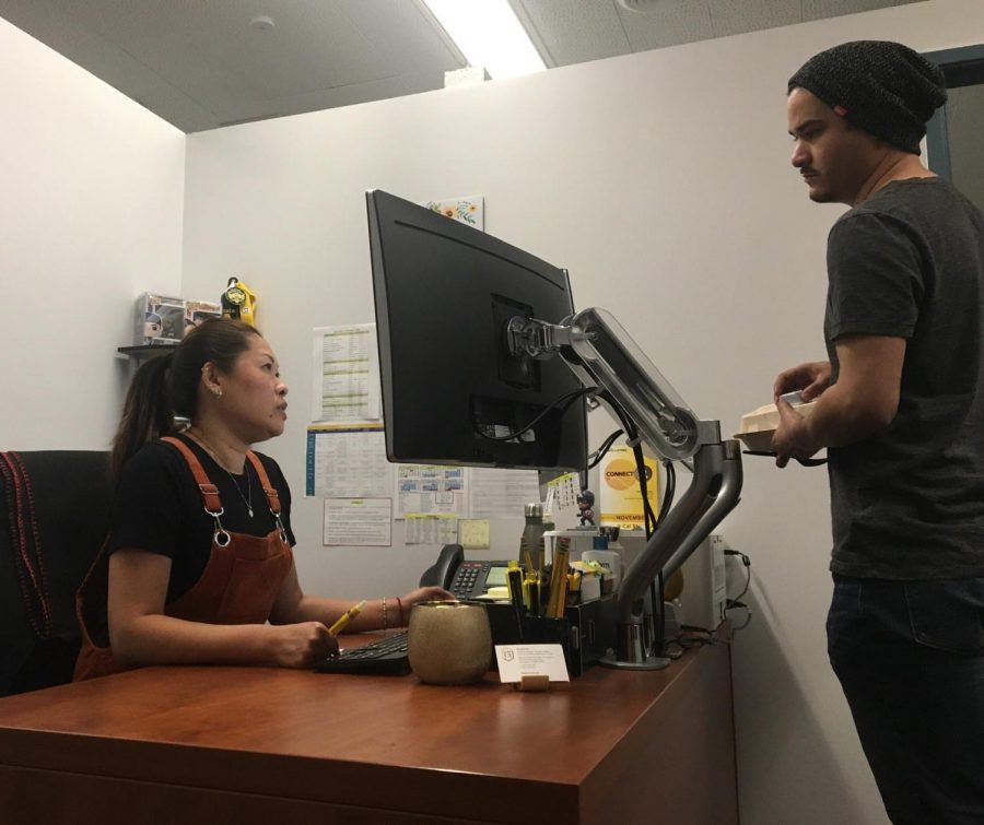 Advisor Jennifer Luo and front desk support Johnny Benitez discuss the appointment schedule.
