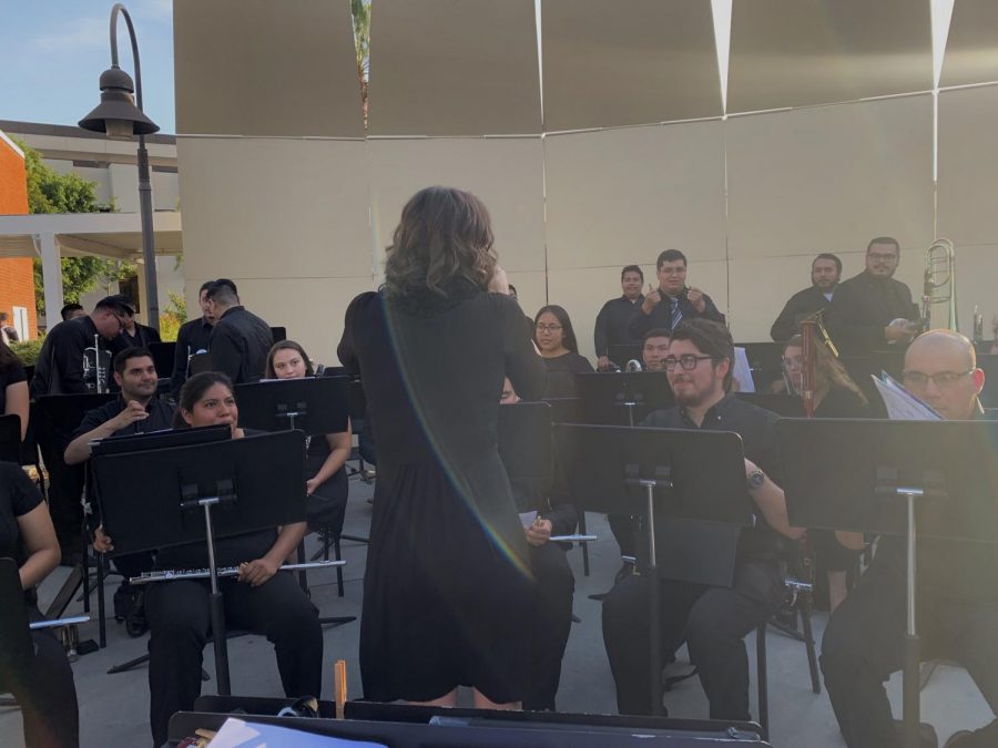 The Cal State LA Wind Ensemble performs in front of the music building courtyard.