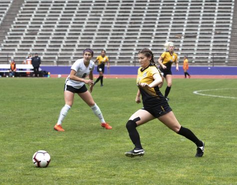 Nicollette Elliott (27) runs and defends the ball.