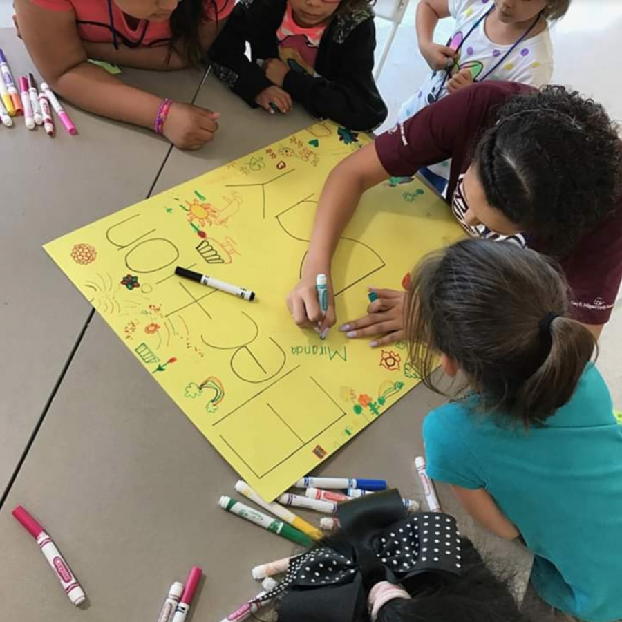 Children in the Boys and Girls Club's child care program help create a poster. Picture taken by Edward Nelson/UT