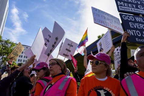 Supporters and volunteers surround a group of counter protesters as signs advocating for the march block the other signs as chants for women's rights and equality are chanted by the supporters in Los Angeles this past Saturday.