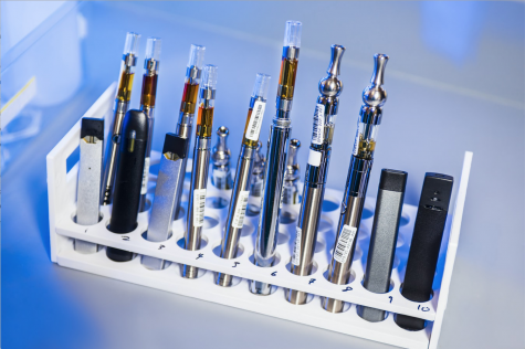 A test tube rack stocked with examples of various electronic cigarettes and vaping pens. Items like this went through testing in a Centers for Disease Control and Prevention laboratory. Photo illustration.