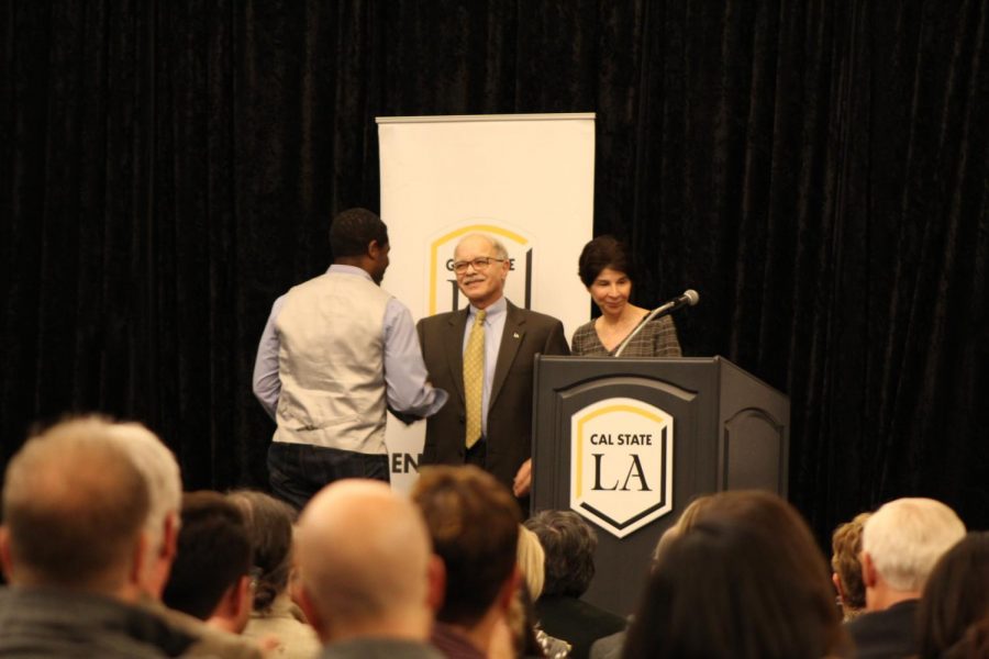 President William A. Covino shaking hands with champion award recipient, staff member Christopher Johnson.