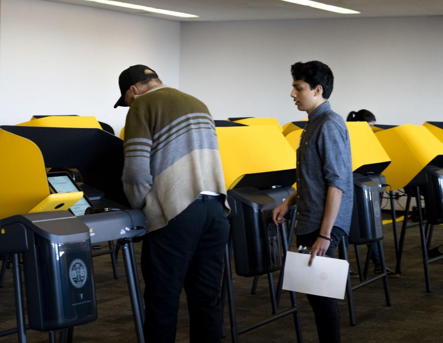 Poll workers were prepared to assist voters through the new electronic voting systems in the Palmer Wing of the Library at Cal State L.A.