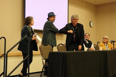 Executive director of the Art Directors Guild Chuck Parker (left) and production designer Rick Carter (right) bump elbows on stage to say hello to one another.