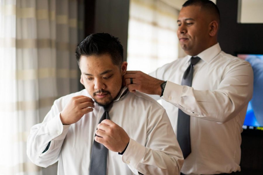 Christopher Lazaro is shown dressed up and having his tie adjusted before a party.