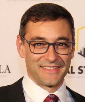 A headshot of Cal State LA professor Martin Adamian, wearing glasses against a university backdrop.