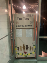 A fridge in the doorway. It reads free food on it and has decals on it of children holding hands.