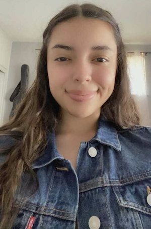 A headshot of Yuliana Lumbreras wearing a jean jacket and smiling.