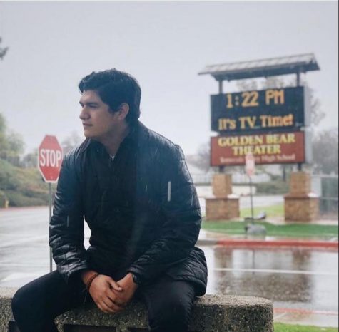 photo of Juan Gomez sitting and starting out into the distance in the rain.