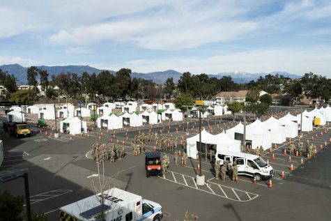 FEMA personnel are seen amongst tents as the federally mandated vaccination site at Cal State LA is being made in the parking lot in front of LACHSA.