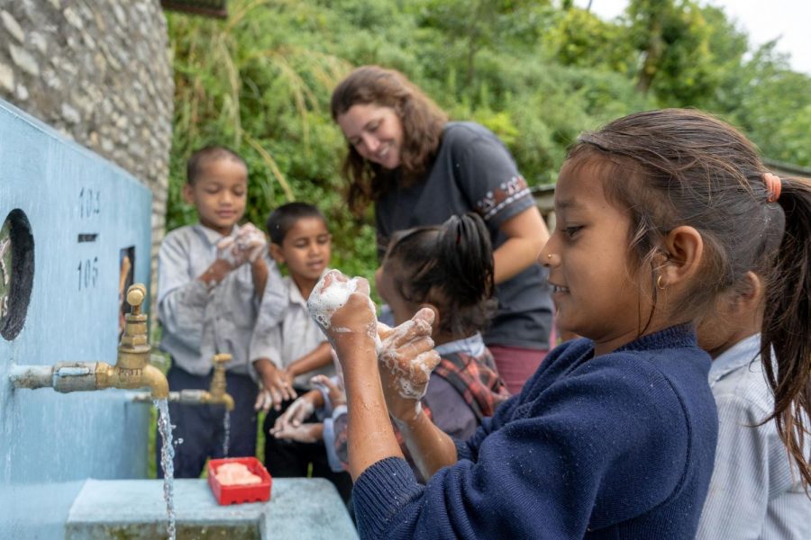 Volunteer helping children wash