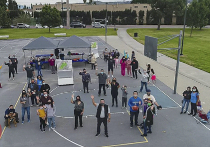 Aerial photo of people standing on a basketball court and waving