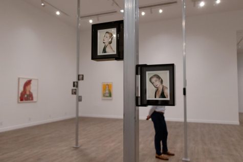 Photo shows two small framed photos of a blonde woman that are stuck to a pole. 