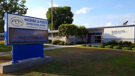 A blue and white sign outside of a white building.