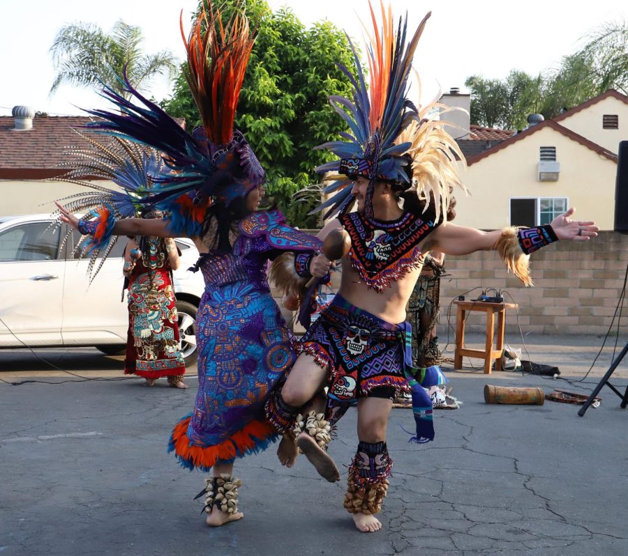 Two+people+in+traditional+clothes+and+colorful+feather+headdresses+dance.