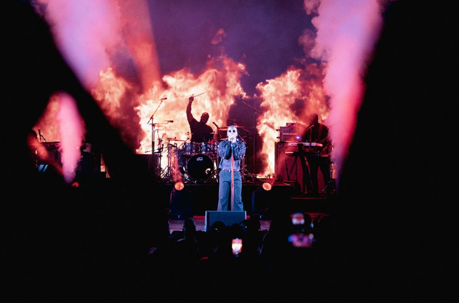 Stage+illuminating+with+purple+and+pink+lighting+and+fire+with+singer+in+the+foreground