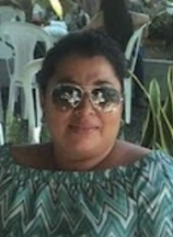 A woman with a green and white shirt and sunglasses