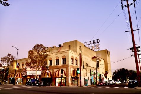 the Photo of two story building and Highland Theatre Hoarding situated on the terrace of it