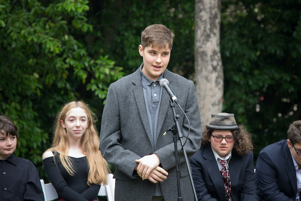 A student speaking in front of classmates at graduation