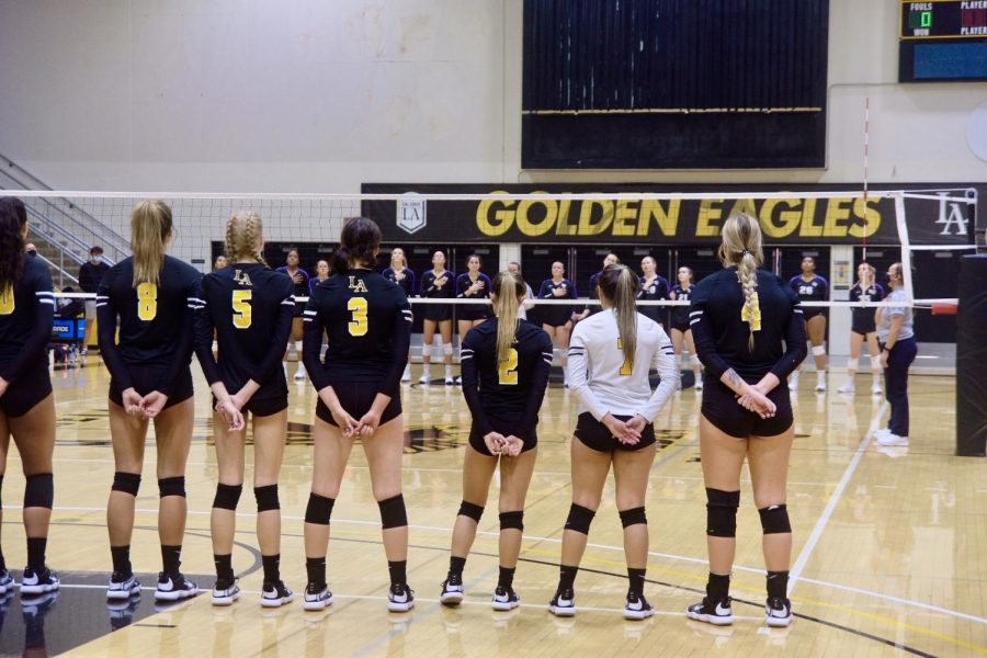 Cal State LA womens volleyball team line up as the national anthem plays in the gym.