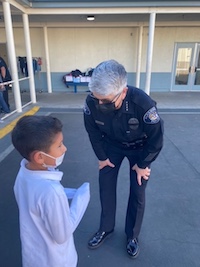 In this photo alhambra police ofiices talking with little boy in the school