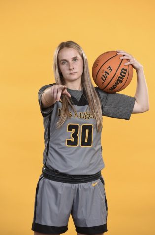 Senior Alyssa Fisher posing for a photo in her uniform, pointing to the camera.