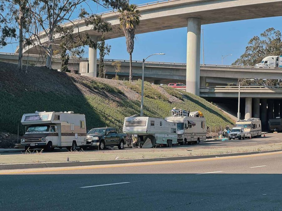 A shot of an underpass with dozens of cars and RVs parked together
