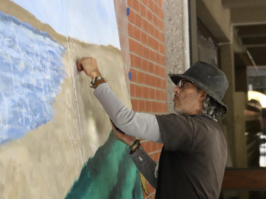 Artist+Claudio+Talavera-Ballon+painting+the+first+part+of+a+mural+in+front+of+the+Cal+State+LA+library.