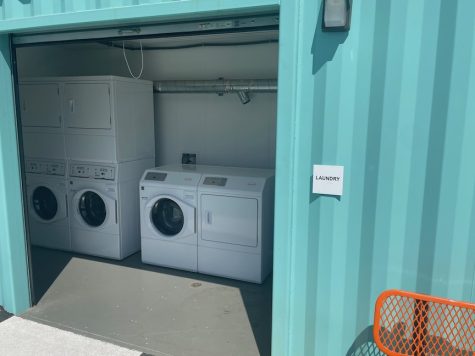 teal green building with no door and white washers and dryers inside