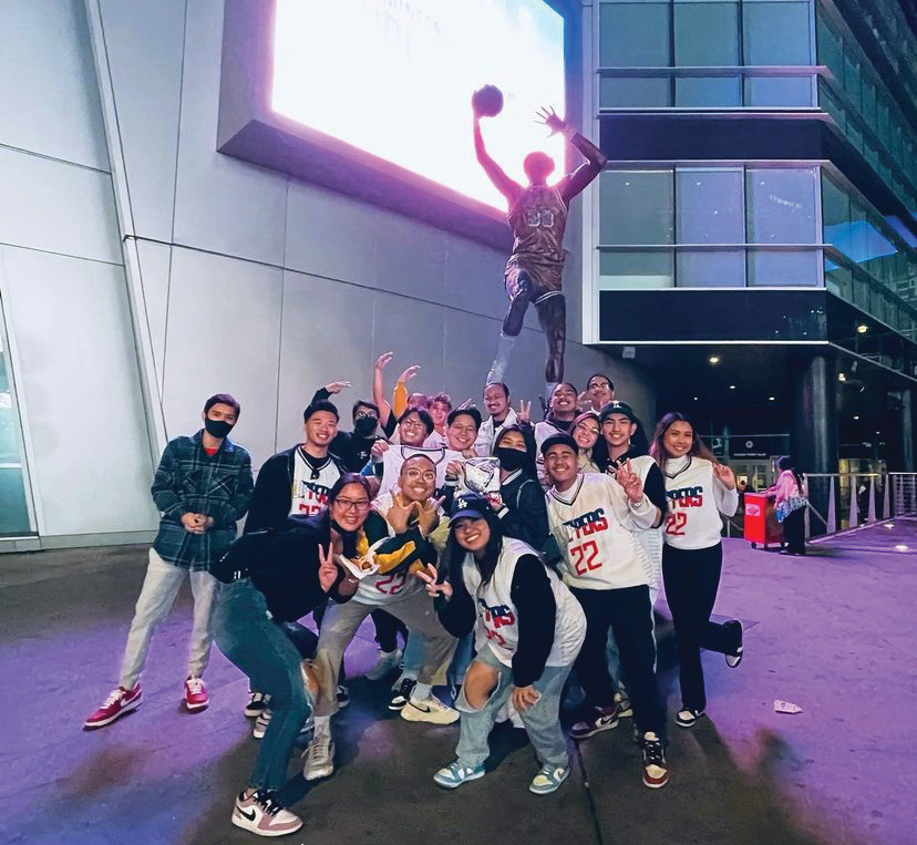 The Filipino club posing in front of a statue at a Clippers game for culture night.