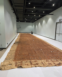 Gallery room with white and grayish walls and brown mat on floor