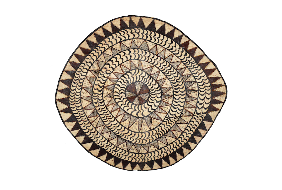 Circular beige mat with dark brown triangular patterns