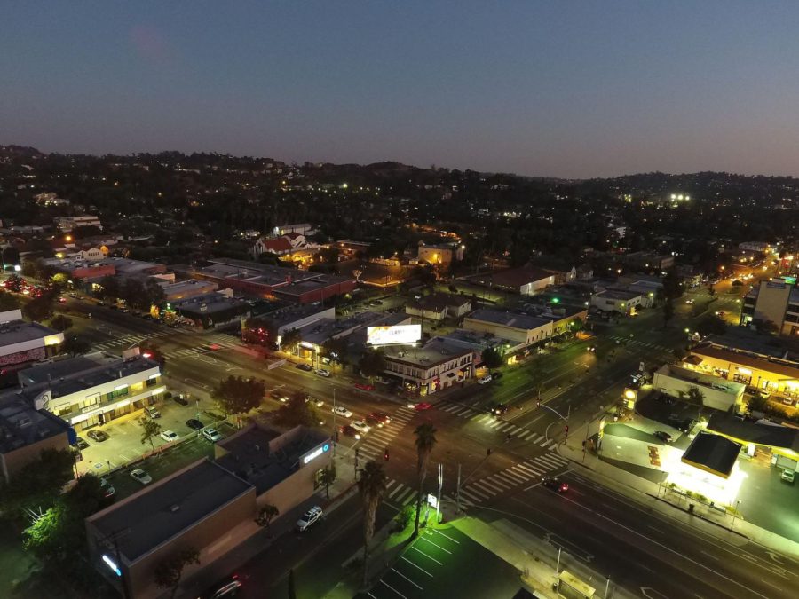 The intersection of Eagle Rock Blvd & Colorado Blvd at dusk is brightly lit with businesses. Photo by Penguinbearlove, license CC BY-SA 4.0.