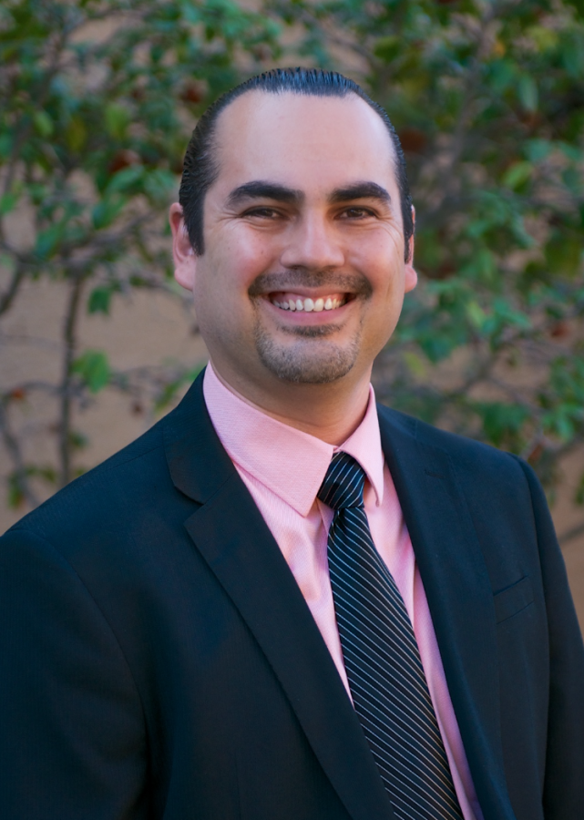 Benjamin Cárdenas posing for a photo wearing a suit and tie.