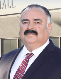 Man with mustache in front of building