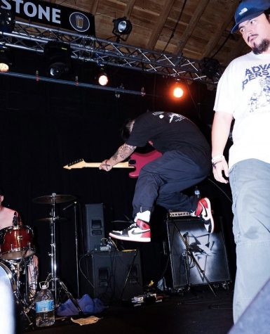 Juan Lopez jumping in the air with his guitar