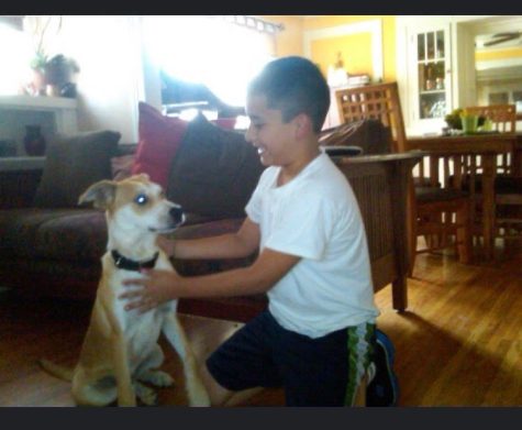 Andres kneels alongside his sitting dog, Hunter.